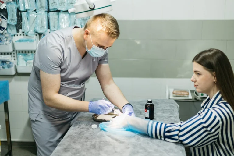 Лікар видаляє новоутворення на шкірі руки пацієнтки, медична мережа ЕКСПЕРТ