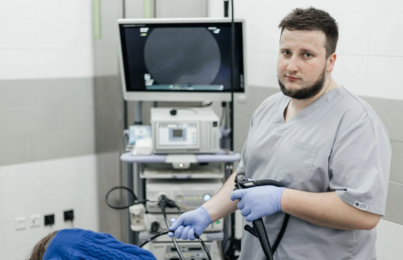 Лікар-ендоскопіст з ендоскопом біля стійки апаратури