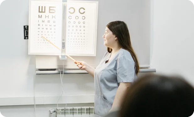 Офтальмологиня перевіряє зір за таблицею